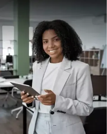Afro descendant businesswoman holding a tablet in an office.