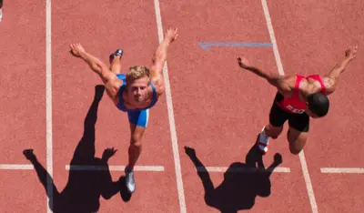 Athletes sprinting toward the finish line on a track during a race.