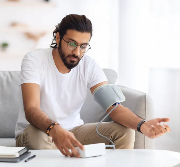 Young man checking his blood pressure with a home blood pressure monitor.