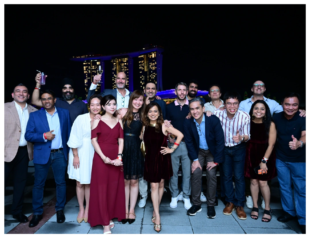 A diverse group poses for a night photo at Singapore's Marina Bay.