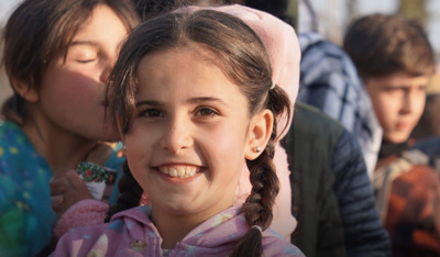 Smiling young girl representing hope in TP for UNICEF earthquake recovery efforts.
