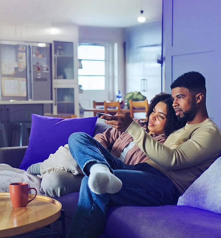 Couple enjoying a shared moment while watching TV at home.