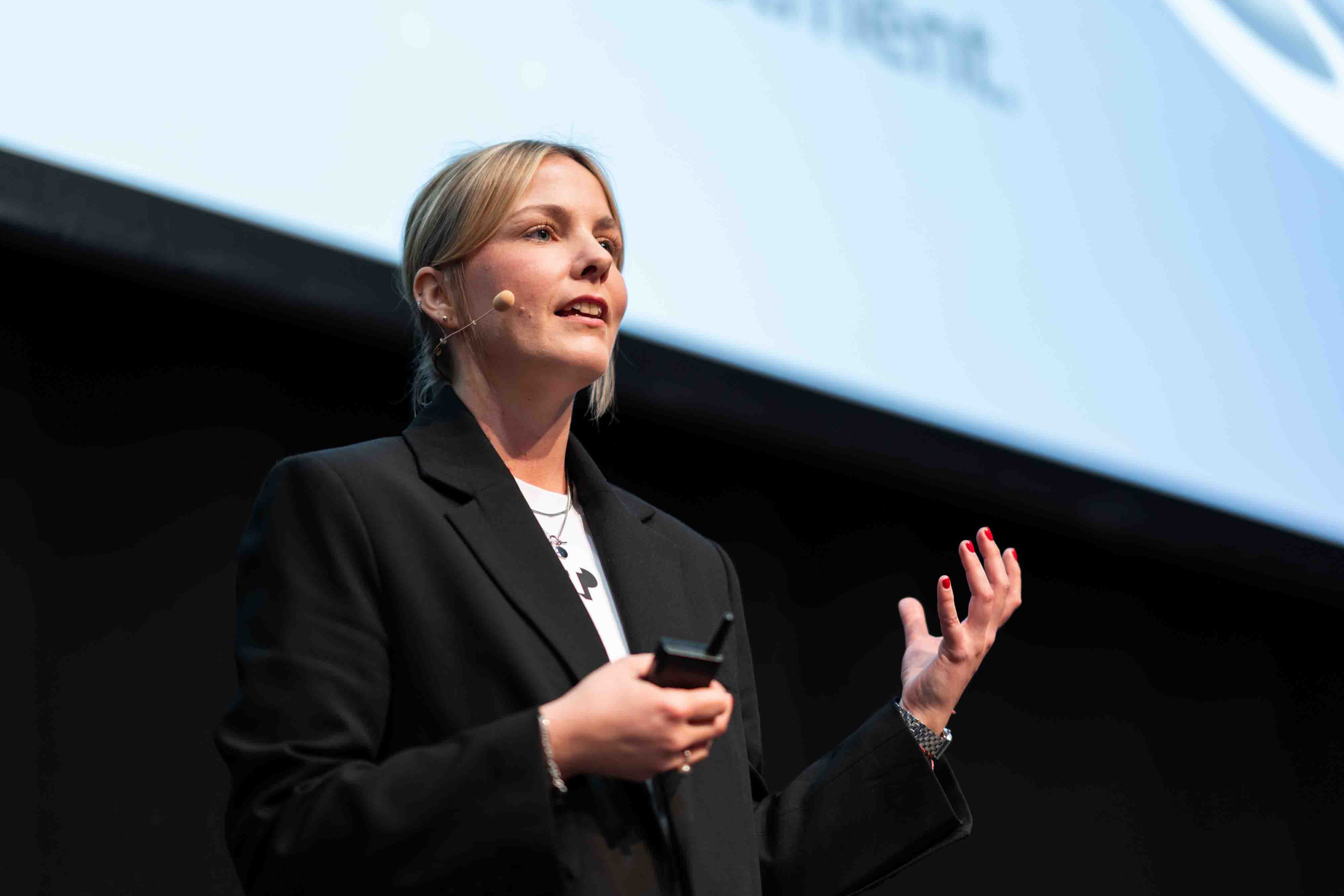 Business professional delivering a talk on stage at an event.