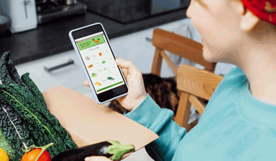 Woman unpacking grocery shopping she ordered through an app