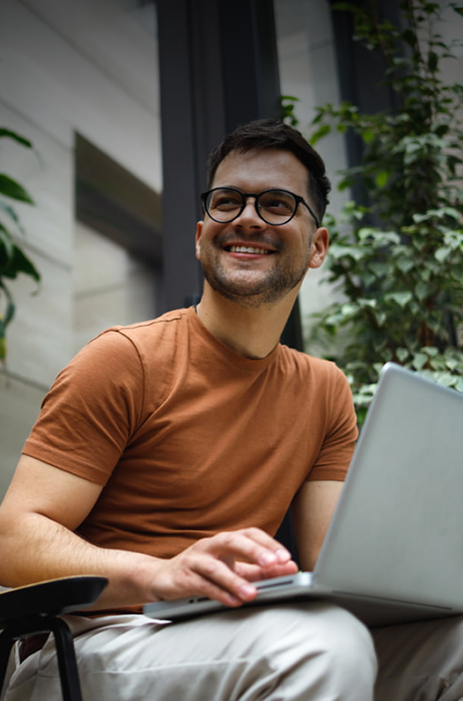 Man working on computer with trees in the background