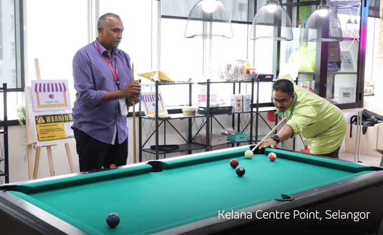 TP employees playing pool together in a company break area.