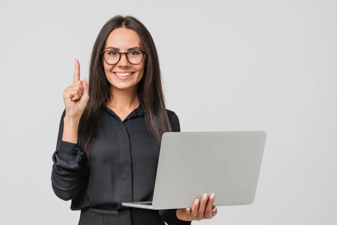 TP employee holding a laptop and smiling while pointing upward.