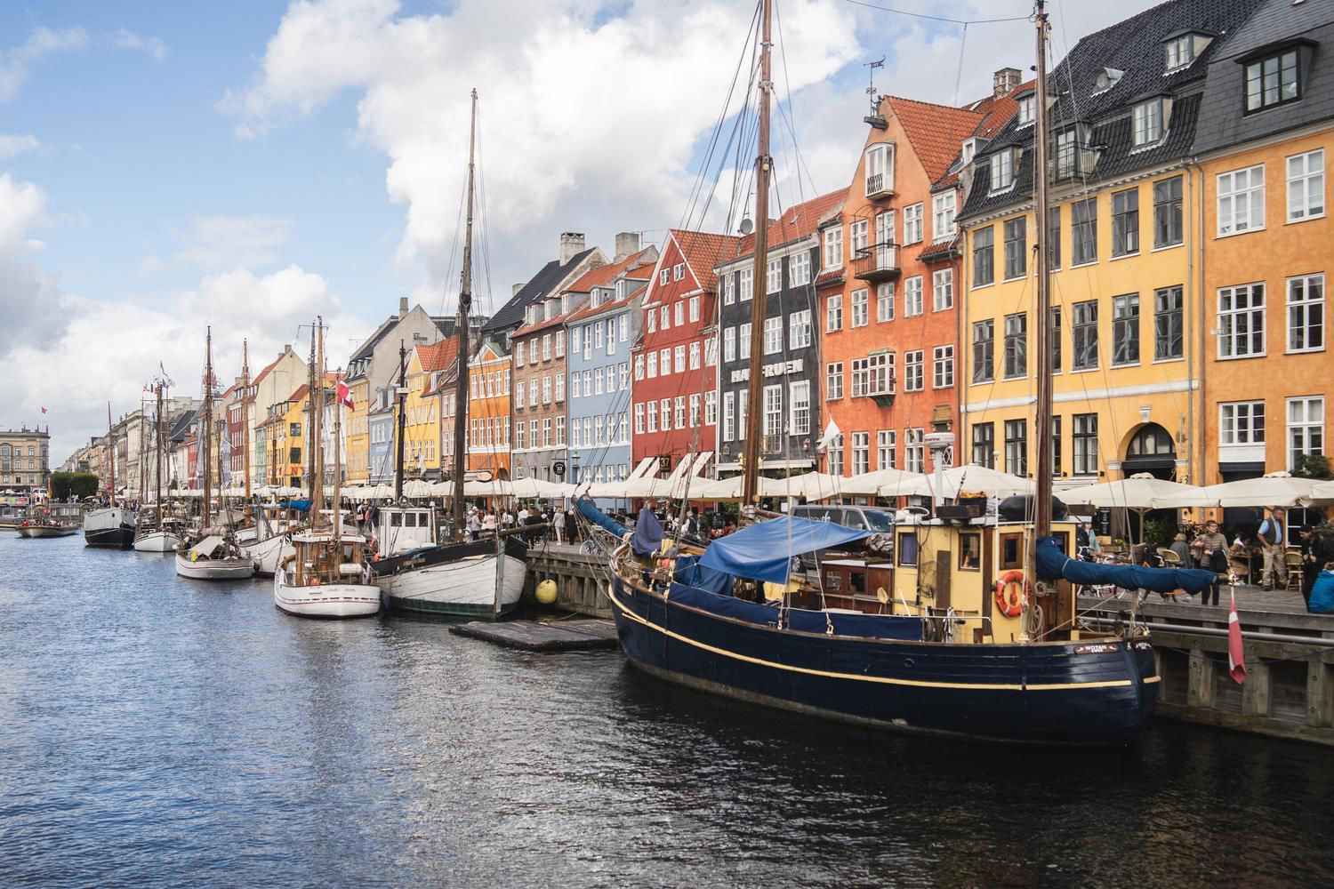 TP banner showing colorful waterfront buildings and boats in Copenhagen harbor.