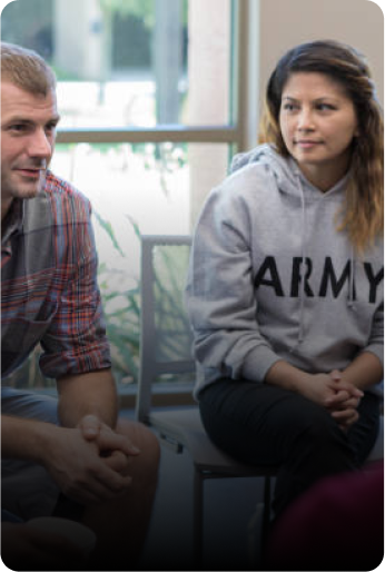 Two people talking, including a person wearing an Army hoodie.