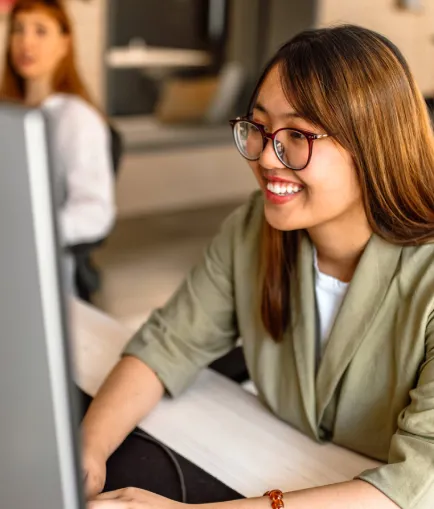 Asian woman working at a computer.