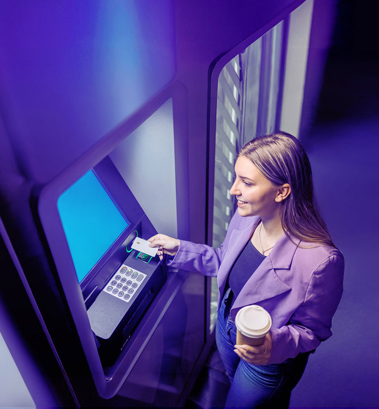 Young woman withdrawing cash from an ATM.