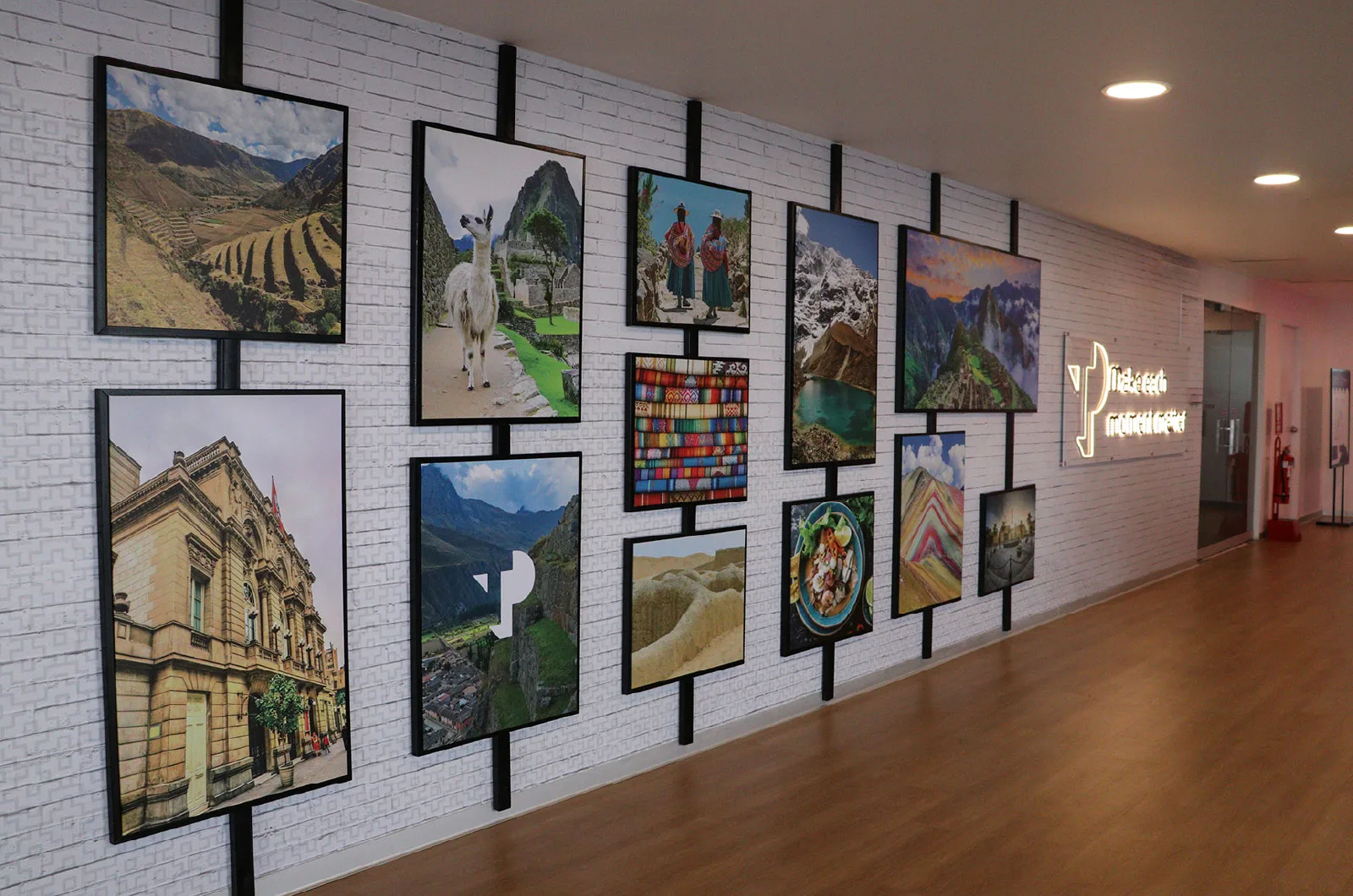 Gallery wall featuring colorful photos of landscapes, culture, and nature with TP branding in the office.