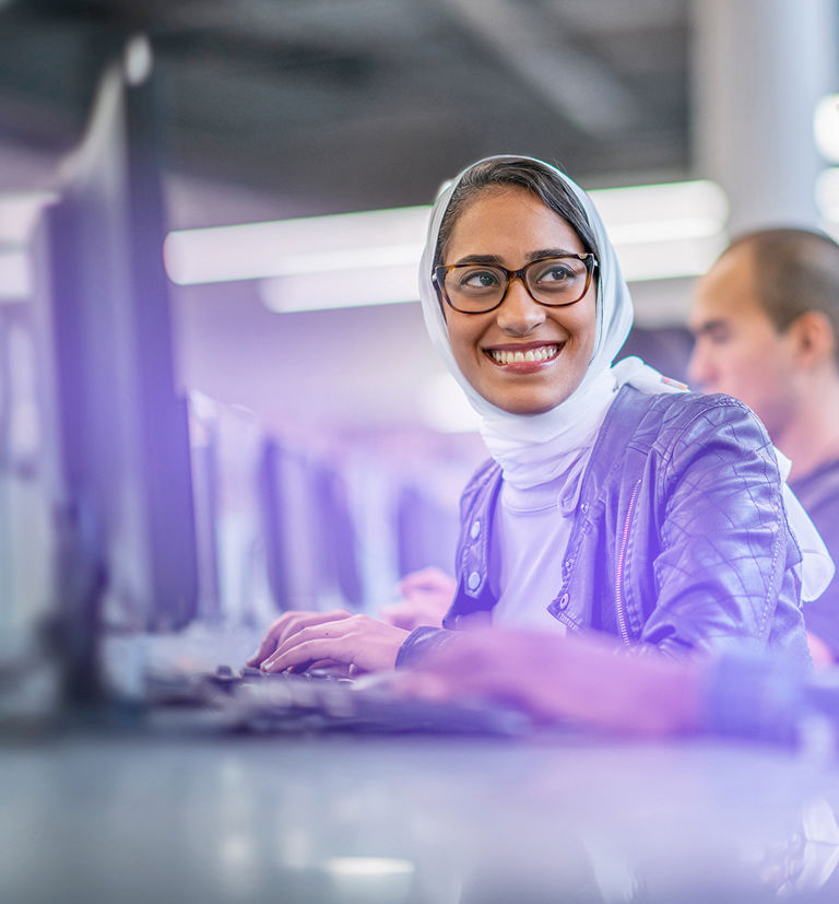 TP multilingual services team member working at a computer in an office.