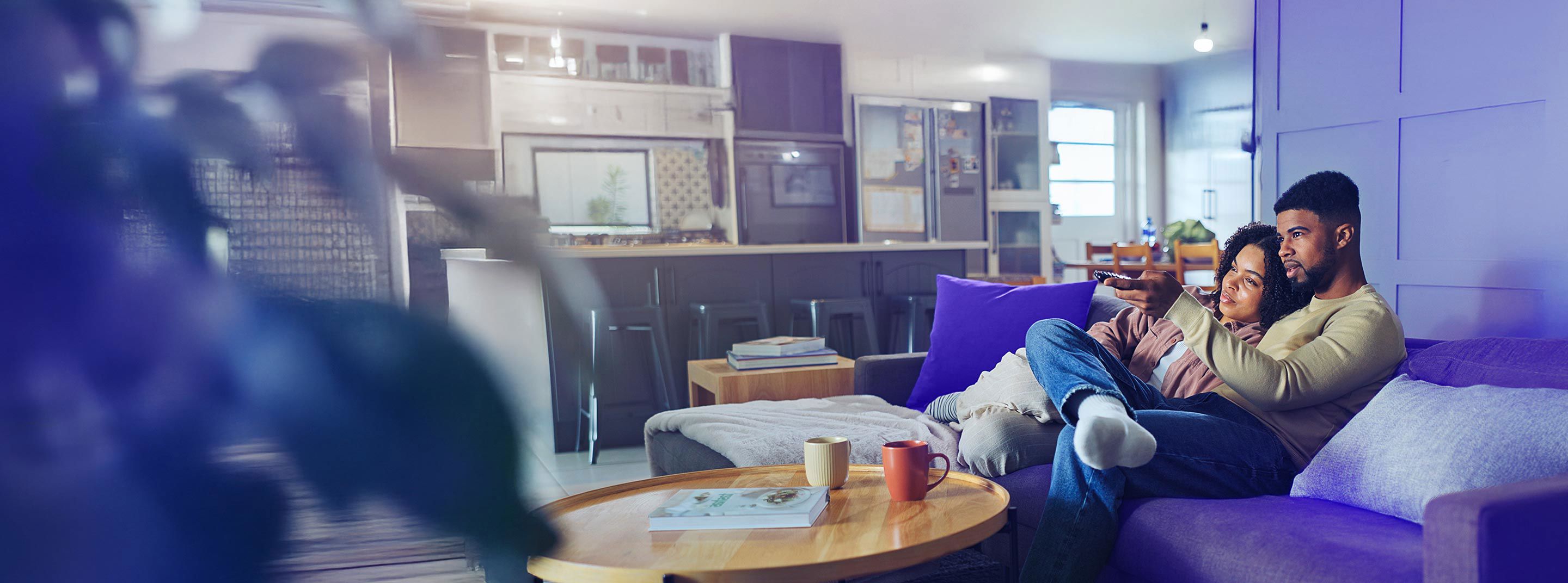 Couple enjoying a shared moment while watching TV at home.