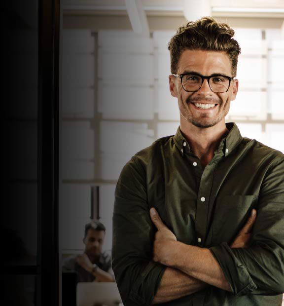 Hombre sonriente con gafas en un entorno de oficina