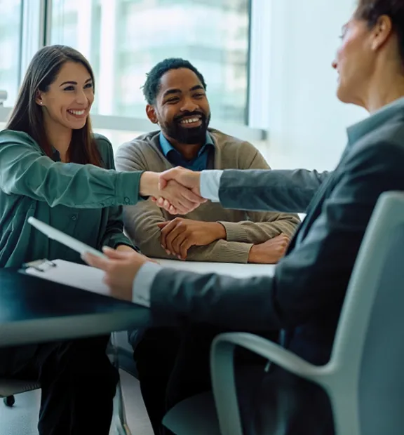 Couple greeting a financial services professional in a business setting.