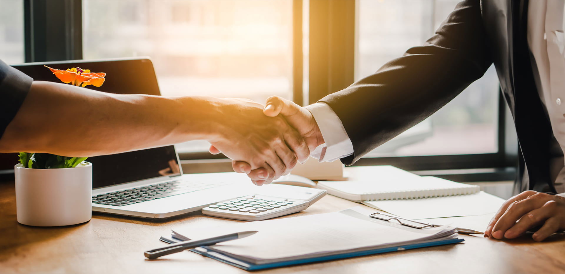 Two businesspeople shaking hands as a sign of a closed agreement, representing TP’s commitment to partnerships.