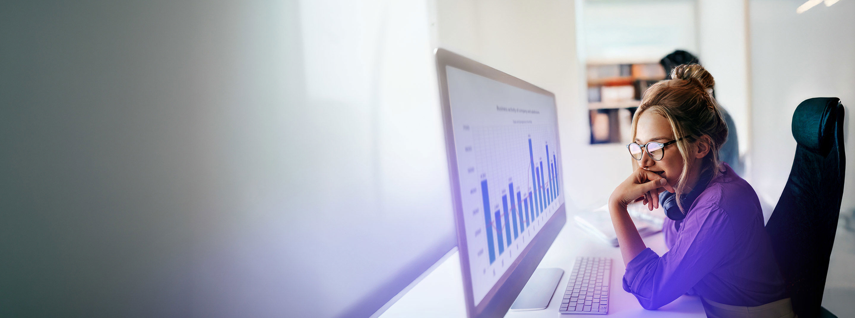 Employee analyzing performance charts on a desktop monitor at TP.